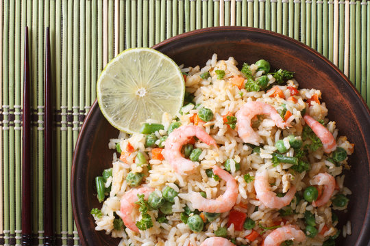 fried rice with shrimp and vegetables closeup, top view