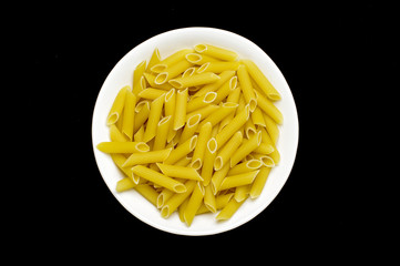 Bowl full of raw penne rigate pasta isolated