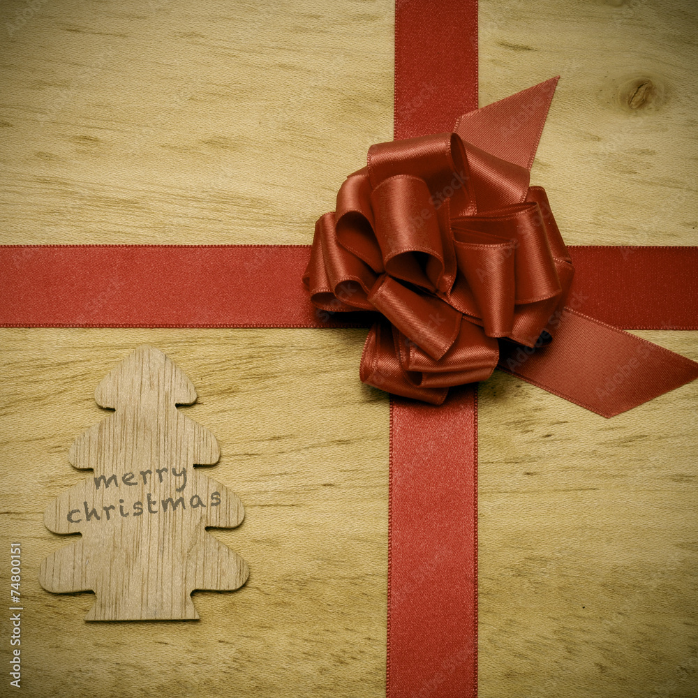 Sticker merry christmas written in a wooden tree and a red ribbon bow