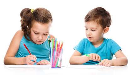 Cute children is drawing on white paper