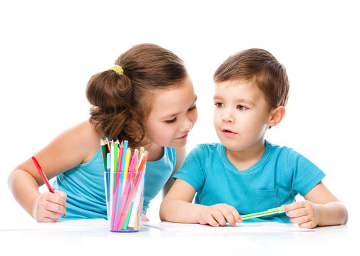 Cute children is drawing on white paper