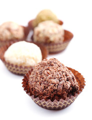 Sweet round candy wrapped in paper bowl on white background