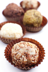 Sweet round candy wrapped in paper bowl on white background