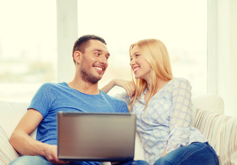 smiling happy couple with laptop at home