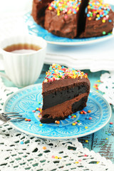 Chocolate cake with colorful sweet powder on table close-up