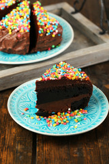 Chocolate cake with colorful sweet powder on table close-up