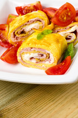 delicious rolls omelette with tomato, ham and cheese cream