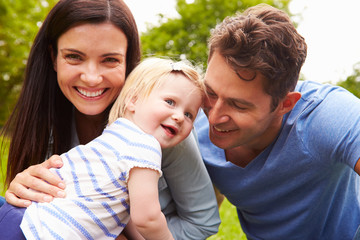 Fototapeta premium Portrait Of Family Playing Game In Garden With Daughter