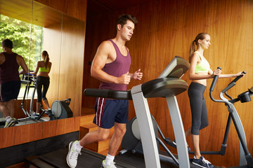 Obraz na płótnie Canvas Couple Exercising Together In Home Gym