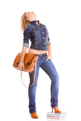 Denim fashion. Full length student girl in blue jeans bag books