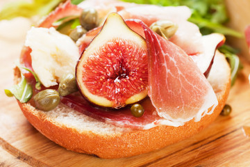 Fototapeta na wymiar Prosciutto sandwich with capers and figs