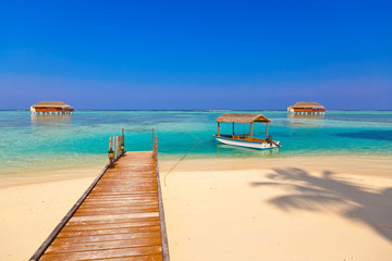 Fototapeta na wymiar Boat and bungalow on Maldives island
