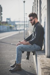 young handsome attractive bearded model man using smartphone