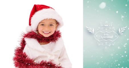 Composite image of cute little girl wearing santa hat and tinsel