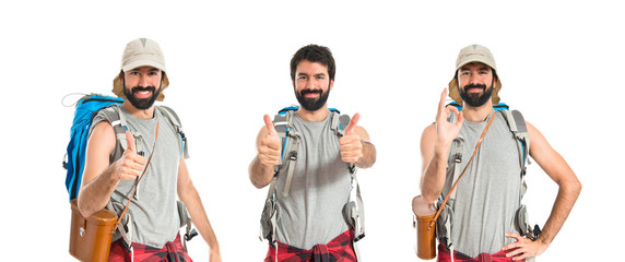 Backpacker with thumb up over white background