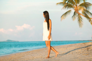Beautiful girl walking on the beach at sunset