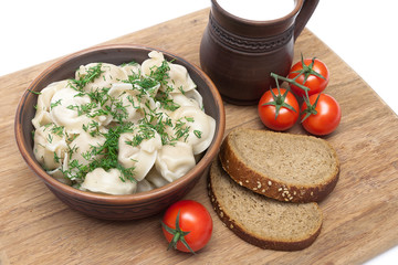 Russian cuisine: dumplings on a plate, tomatoes and bread on the