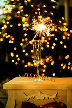 Beautiful sparkler in glass on shiny background, close up