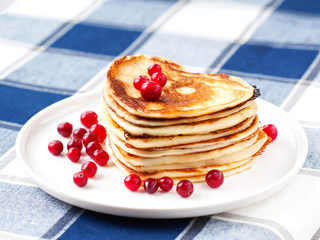 Heart shaped pancakes with cranberries on white  porcelain plate