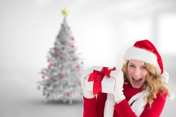 Pretty santa girl smiling at camera holding gift