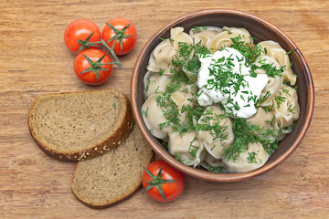 dumplings with fresh herbs and sour cream in a dish, cherry toma