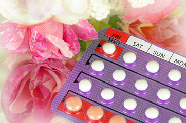 28 Tablets Contraceptive Pills with Day Labeled on Start Date with Soft Floral Background.