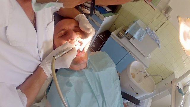Dentist using dental dril preparing for implant,artificial teeth