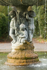 Fototapeta na wymiar Ornamental fountain with figures of children in the park