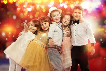 Group of happy kids with colorful lights on background.