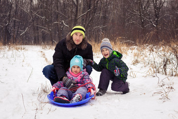 Image of adult with two children on a sled