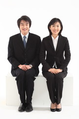 앉아서 제스처 취하고 있는 아시안 비즈니스 남성과 여성