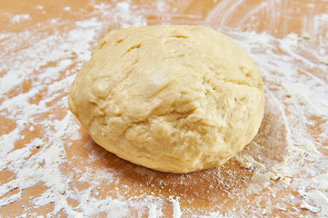 Fototapeta na wymiar Knead dough on wooden table