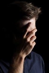 Fototapeta premium Worried or embarrassed man on black