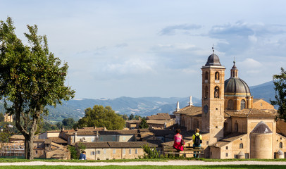 couple admires panorama of Urbino, Italy