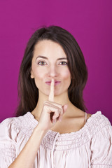 Naklejka premium Portrait of a confident young woman with a finger on her lips