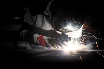 Employee welding steel using MIG/MAG welder.
