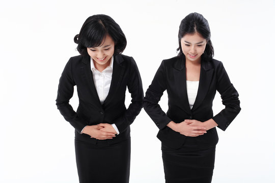 서서 제스처를 취하는 두 명의 아시안 비즈니스 여성
