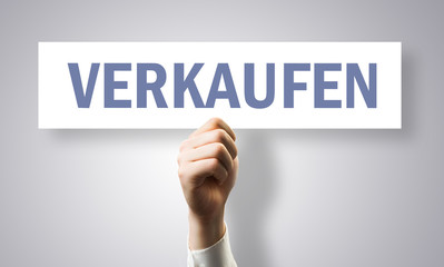 Hand hält Schild mit Text 