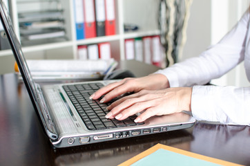 Businesswoman typing on a laptop