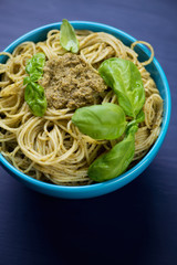 Close-up of spaghetti with pesto sauce, vertical shot