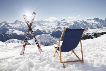 Cross ski and Empty sun-lounger at mountains