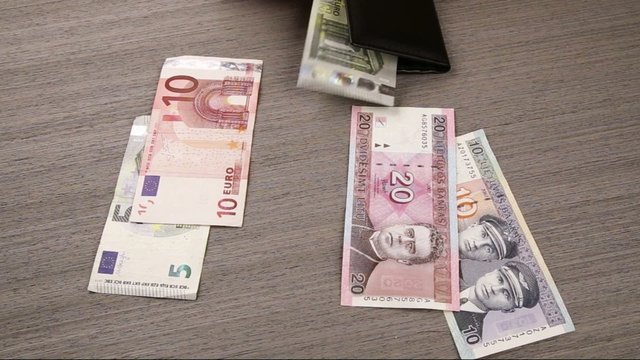 hands taking out litas and putting in euros in wallet