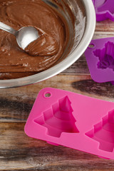 Steps of making chocolate cake: filling silicone mold with pastr