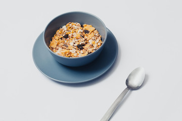 Muesli in a bowl and spoon. White background.
