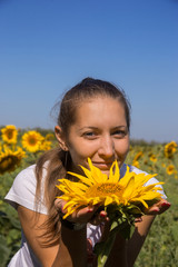 Young woman with sunflower in field