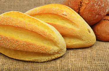 Fresh wheat buns on the sacking background.