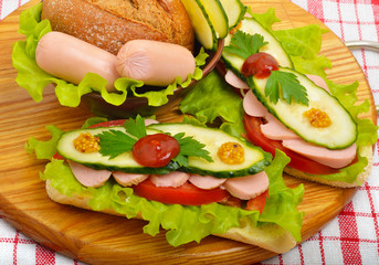 Big appetizing fast food baguette sandwich with lettuce, tomato