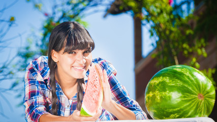 Healthy young woman-eating watermelon on a sunny day