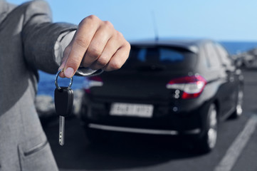 man offering a car key to the observer