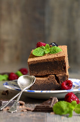 Brownies decorated with raspberry and mint leaf.
